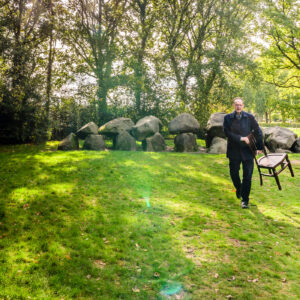 Peter Hendriks van Uitvaartzorg BijZonder met een lege stoel bij de Hunebedden in Rolde